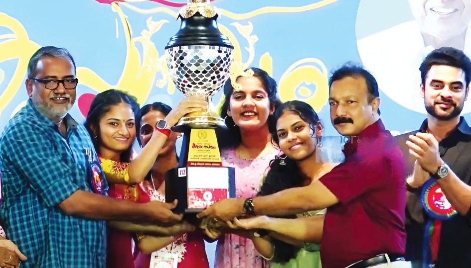 Minister P Prasad presents trophy to Mannar Nair Samajam School for winning the overall art title at the State School Art Festival
