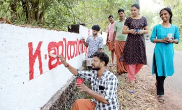 എൽഡിഎഫ്‌ സ്ഥാനാർഥികൾക്കുവേണ്ടി ചുവരെഴുതുന്നവർ. കൊടക്കാട്‌ കണ്ണാടിപ്പാറയിൽനിന്നുള്ള ദൃശ്യം