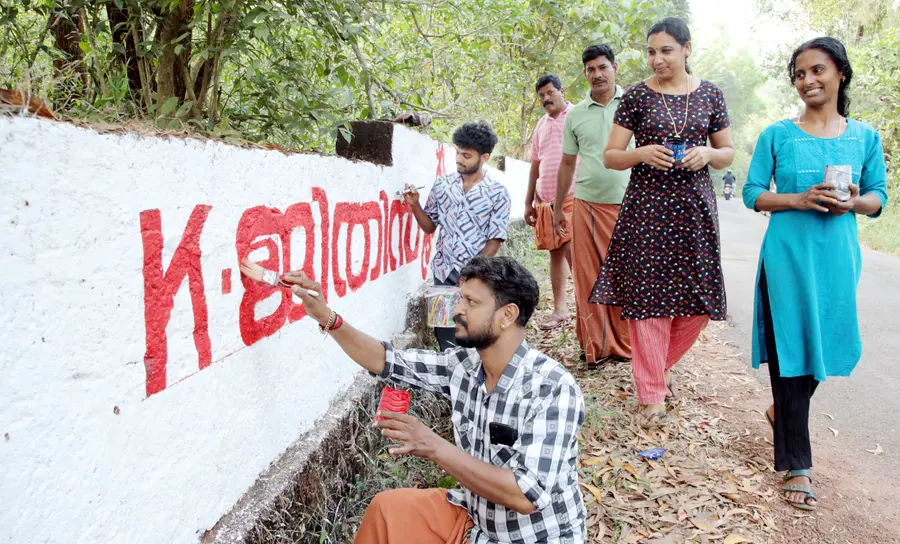 എൽഡിഎഫ് സ്ഥാനാർഥികൾക്കുവേണ്ടി ചുവരെഴുതുന്നവർ. കൊടക്കാട് കണ്ണാടിപ്പാറയിൽനിന്നുള്ള ദൃശ്യം