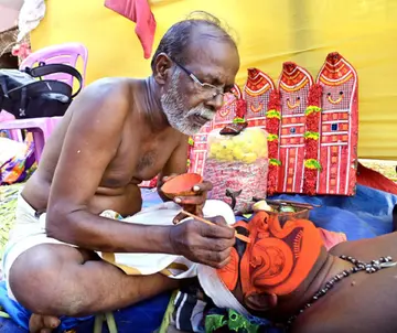 സി കെ നാരായണൻ കിനാനൂർ കൊവ്വൽ തറവാട്ടിൽ  നടന്ന കളിയാട്ടത്തിൽ ദണ്ഡ്യങ്ങാനത്ത് ഭഗവതിയുടെ  മുഖത്തെഴുത്തിൽ ഏർപ്പെട്ടപ്പോൾ 