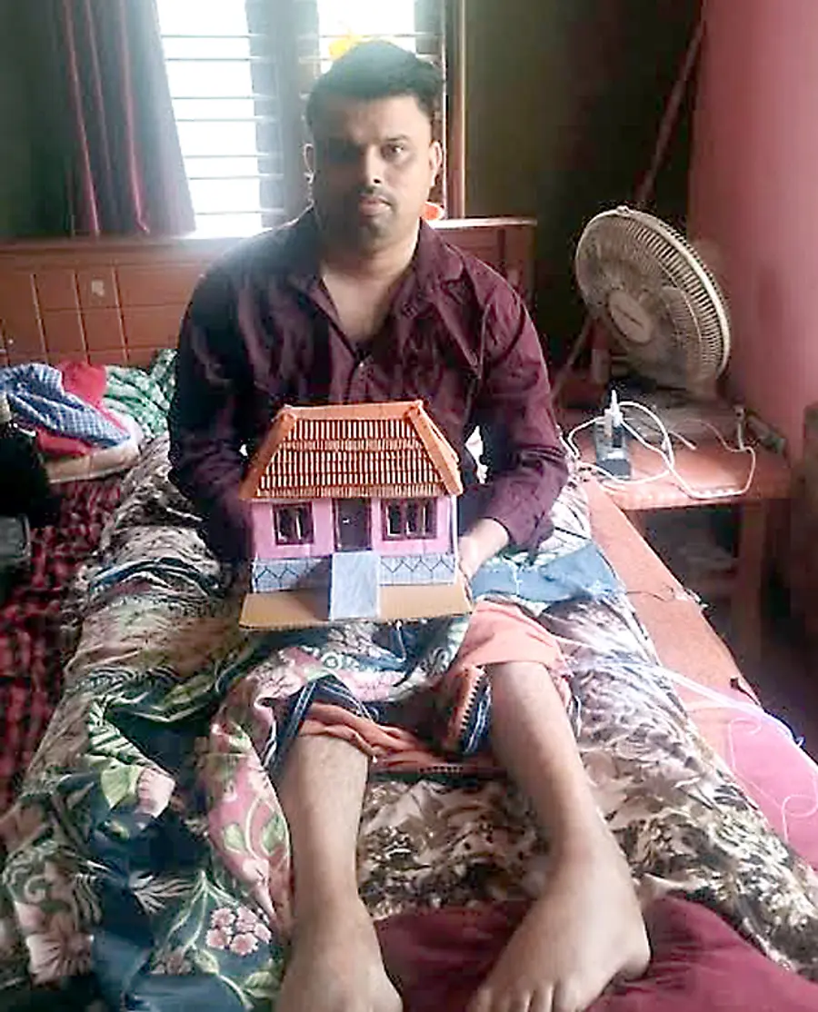 അരയ്‌ക്കുതാഴ തളർന്ന്‌ കിടപ്പിലായ പേരിയയിലെ സനോജ്‌  പാഴ്‌വസ്‌തുക്കളിൽ നിർമിച്ച തന്റെ സ്വപ്‌ന ഭവനവുമായി 