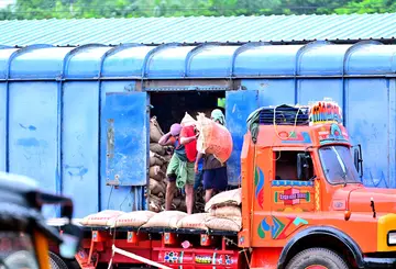മേൽക്കൂരയില്ലാത്ത ഗുഡ്സ്  ഷെഡ്ഡിൽനിന്ന്‌ മഴയത്ത്  തൊഴിലാളികൾ  ലോറികളിലേക്ക് ലോഡ്  കയറ്റുന്നു
