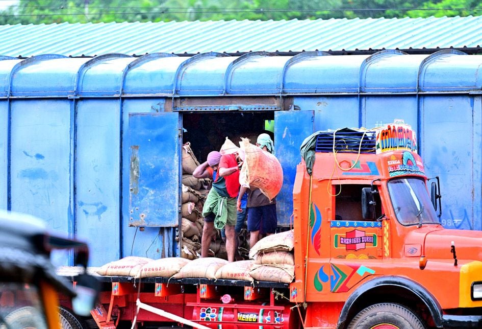 മേൽക്കൂരയില്ലാത്ത ഗുഡ്സ്  ഷെഡ്ഡിൽനിന്ന്‌ മഴയത്ത്  തൊഴിലാളികൾ  ലോറികളിലേക്ക് ലോഡ്  കയറ്റുന്നു