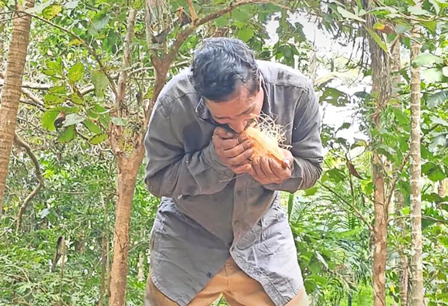 അംഗജൻ പല്ലുപയോഗിച്ച് തേങ്ങ പൊതിക്കുന്നു