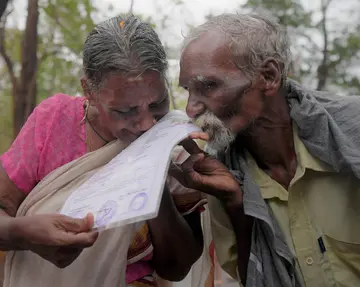 ഒളകരയിൽ ഭൂമി സ്വന്തമായി കിട്ടിയ സന്തോഷത്തിൽ കൈയ്യിൽ കിട്ടിയ രേഖയിൽ മുത്തമിടുന്ന ദമ്പതികൾ വേലായുധനും തങ്കയും  