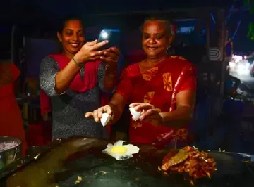 പവർകട്ടിനെ തുടർന്ന് കൊല്ലം ബീച്ച് റോഡിലെ തട്ടുകടയിൽ മൊബൈൽ വെളിച്ചത്തിൽ ആഹാരം പാചകം ചെയ്യുന്നവർ