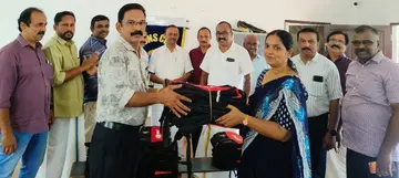 ലയൺസ് ക്ലബ് പ്രസിഡന്റ്‌ ഗണേഷ്‌കുമാറിൽനിന്ന്‌ കെപിഎംയുപിഎസ്  പ്രഥമാധ്യാപിക മായ ചന്ദ്രൻ ബാഗുകൾ ഏറ്റുവാങ്ങുന്നു