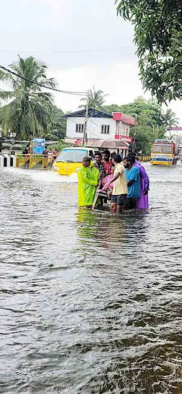 എ സി റോഡിൽ മങ്കൊമ്പ് ബ്ലോക്ക് ജങ്ഷനിൽ സ്‌ത്രീയെ ക്യാമ്പിലേക്ക് മാറ്റുന്നു 