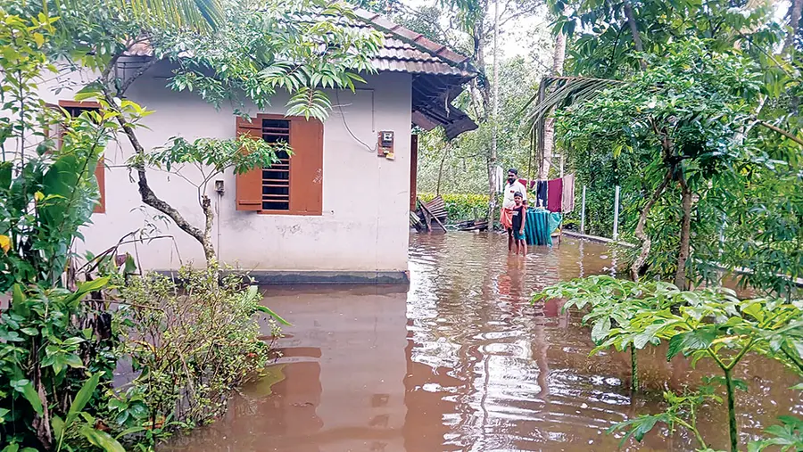 വെളളം കയറിയ വീടിന് പുറത്ത് നിൽക്കുന്നവർ