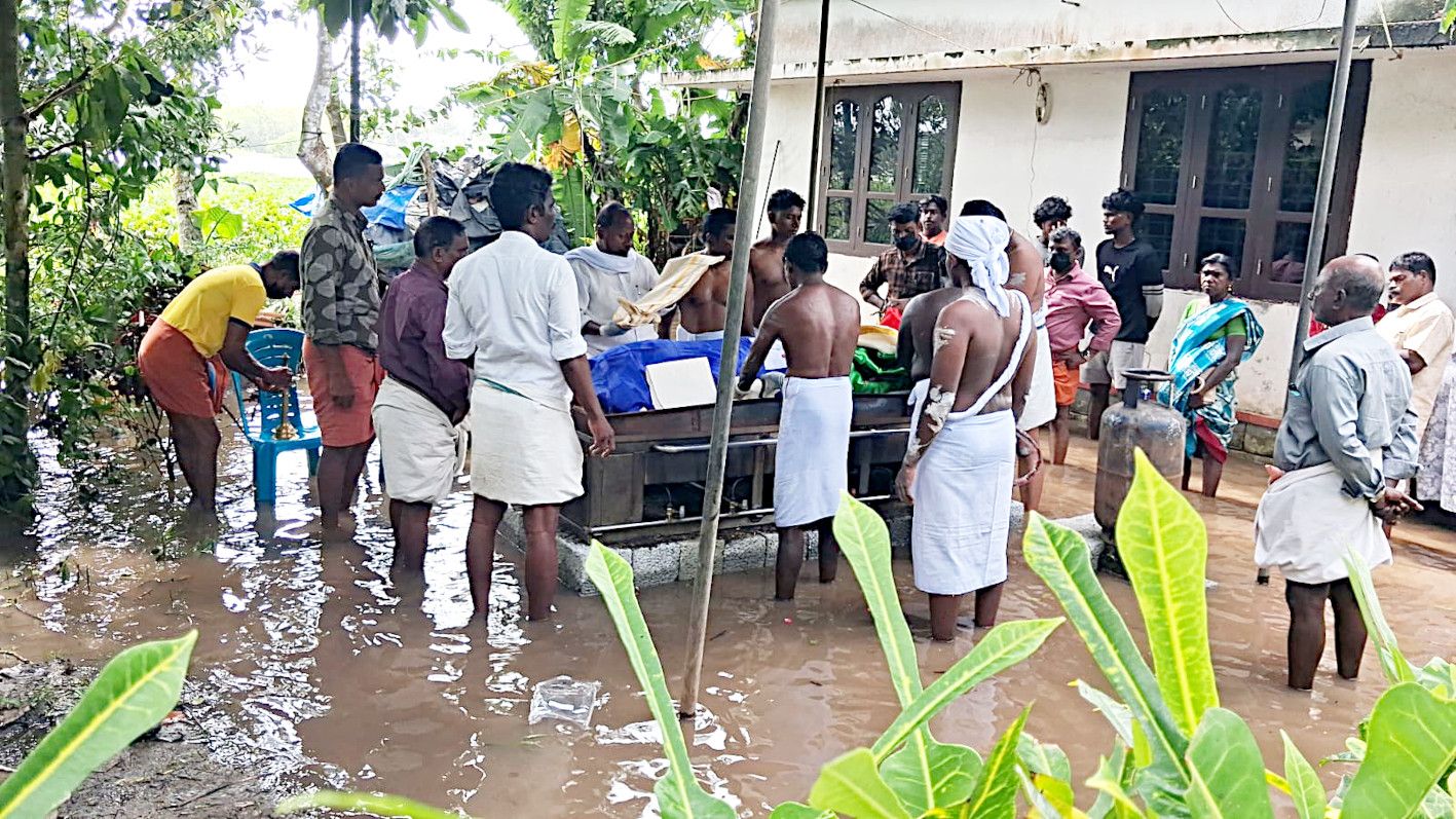 ക്യാമ്പിലേക്ക് പോകുന്നതിനിടെ തോട്ടിൽവീണ് മരിച്ച ഓമനയുടെ മൃതദേഹം  താൽക്കാലിക സംവിധാനമൊരുക്കി സംസ്‌കരിക്കുന്നു