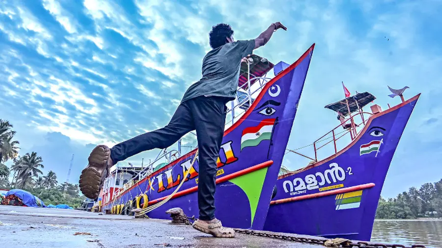 പെരുമാതുറ ഫിഷിങ് ഹാർബറിൽ ചൂണ്ടയിൽ മീൻപിടിക്കുന്ന യുവാവ്. ട്രോളിങ് നിരോധനത്തോട്
അനുബന്ധിച്ച് തീരത്ത് അടുപ്പിച്ച ബോട്ടുകൾ കാണാം ഫോട്ടോ: എ ആർ അരുൺരാജ്