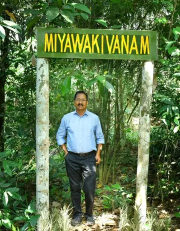 പുരയിടത്തിലെ മിയാവാക്കി വനത്തിന് മുന്നിൽ തോമസ്  ​
