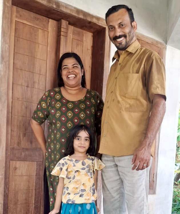 റിജീഷും രേഷ്മയും  മകൾ ആദ്യയോടൊപ്പം    വീടിനുമുന്നിൽ