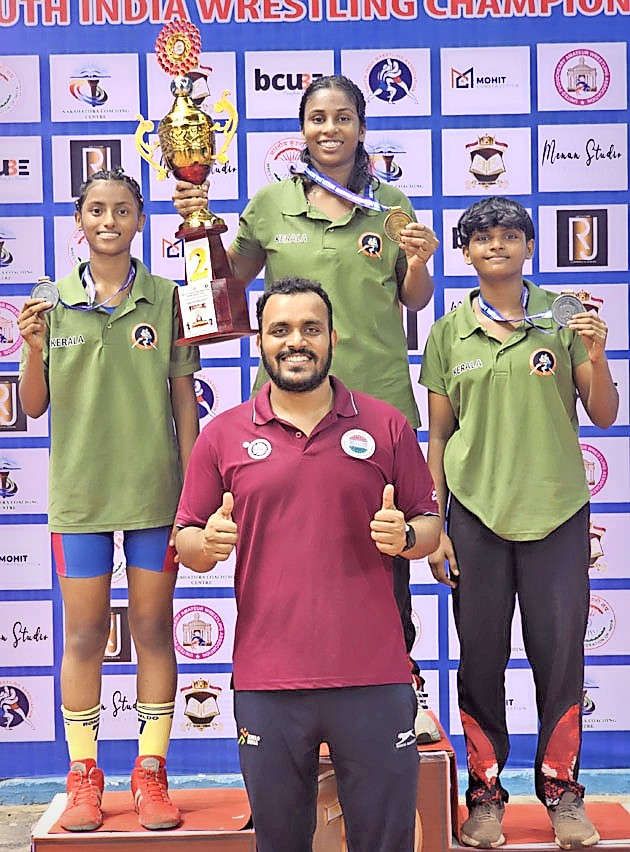 അണ്ടർ 15 സ‍ൗത്ത്‌ ഇന്ത്യാ ഗുസ്തി ചാന്പ്യൻഷിപ്പിൽ മൂന്ന്‌ മെഡൽ വാരിക്കൂട്ടിയ ഉളിക്കൽ  അറബിക്കുളത്തെ അനീറ്റ ബിജു, കോളയാട്ടെ നിഹാര ഷൈജു, കോഴിക്കോട്‌ സ്വദേശി  വൈഗാ ലക്ഷ്മി എന്നിവർ കോച്ച്‌ അഭിഷേക്‌  സിങ്ങിനൊപ്പം