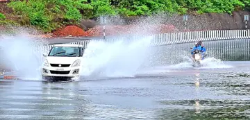 ദേശീയപാത രണ്ടാംറീച്ചിൽ പെരിയാട്ടടുക്കത്ത് കനത്ത മഴയിലുണ്ടായ വെള്ളക്കെട്ടിലൂടെ കടന്നുപോകുന്ന കാർ