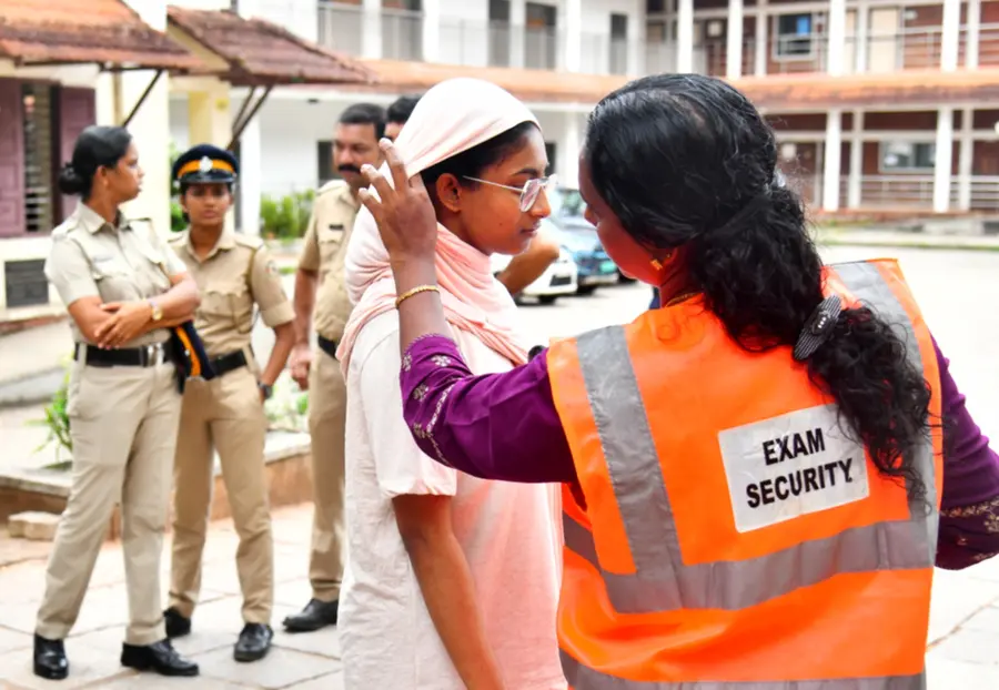 വീഴ്ചയൊരുക്കിയ സുരക്ഷ ... നീറ്റ് യുജി ചോദ്യപേപ്പര് ചോര്ച്ചയെ തുടര്ന്ന് മാറ്റി വച്ച പരീക്ഷയ്ക്കായി കോഴിക്കോട് നടക്കാവ് ഗവ. വിഎച്ച്എസ്എസ് ഫോര് ഗേള്സിലെ കേന്ദ്രത്തിലേക്ക് പ്രവേശിക്കുന്ന വിദ്യാര്ഥിയെ പരിശോധിക്കുന്ന സെക്യൂരിറ്റി