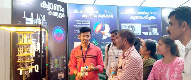ക്വാണ്ടം ശതാബ്ദി  പ്രദർശനത്തിൽ വിദ്യാർഥികൾ വെർച്വൽ റിയാലിറ്റിയിലൂടെ കണികാ പരീക്ഷണം കാണുന്നു