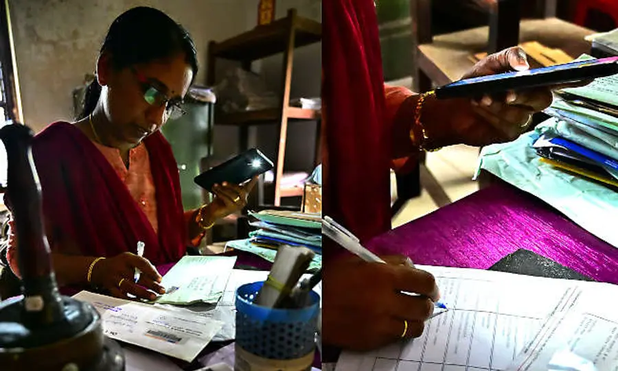 ആർഡി നഗർ പോസ്റ്റ് ഓഫീസിലെ ഉദ്യോഗസ്ഥ മൊബൈൽ ഫ്ലാഷ് വെളിച്ചത്തിൽ ജോലിചെയ്യുന്നു
