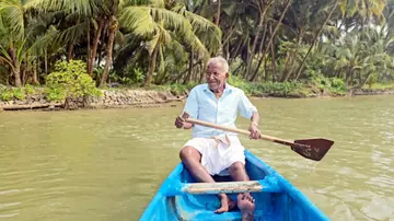 വി ശ്രീധരൻ കവ്വായിക്കായലിൽ തോണി തുഴയുന്നു