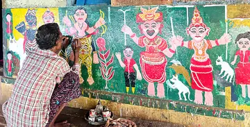 ബേഡകം ചെമ്പക്കാട് ഉന്നതിയിലെ കുഞ്ഞിക്കണ്ണൻ പഴയ വീടിന്റെ ചുമരിൽ ചിത്രം വരക്കുന്നു
