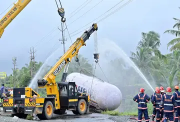 വാതക ചോർച്ച അടച്ചശേഷം കാഞ്ഞങ്ങാട് സൗത്തിൽ മറിഞ്ഞ  ലോറിയിലെ ടാങ്കർ  ഖലാസികൾ ക്രെയിൻ ഉപയോഗിച്ച് ഉയർത്തുന്നു. ഫോട്ടോ: സുരേന്ദ്രൻ മടിക്കൈ