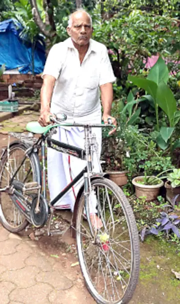 തന്റെ സൈക്കിളുമായി വി കുഞ്ഞിക്കോരൻ പണിക്കർ