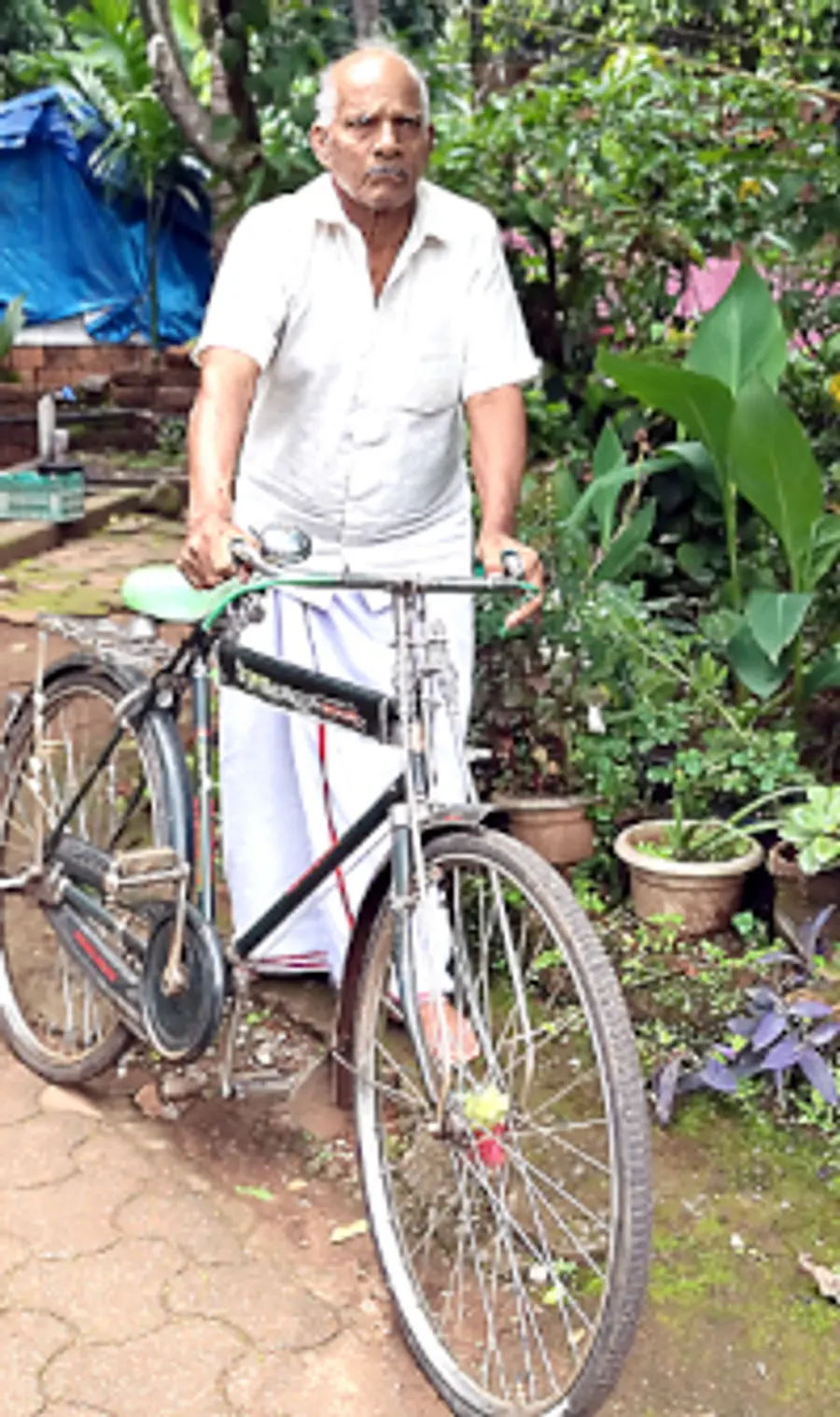 തന്റെ സൈക്കിളുമായി വി കുഞ്ഞിക്കോരൻ പണിക്കർ