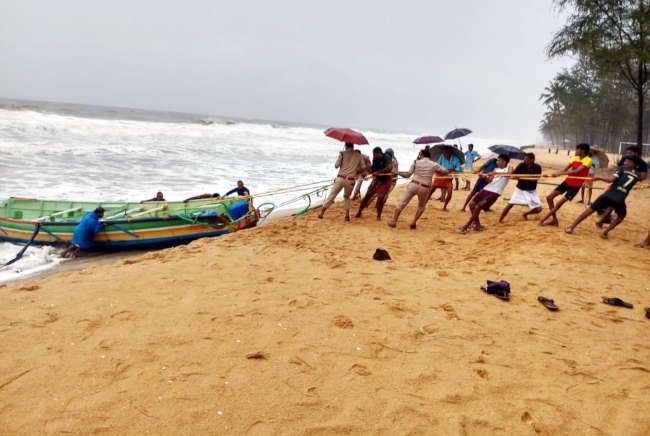 കടലിൽ അപകടത്തിൽപ്പെട്ടതെന്ന് കരുതുന്ന മീൻപിടിത്ത ബോട്ട് വലിയപറമ്പ് കടപ്പുറത്ത് നാട്ടുകാരും കോസ്റ്റൽ പൊലീസുംചേർന്ന് കരയിലേക്ക് കയറ്റുന്നു