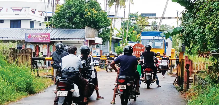 അരൂർ കെൽട്രോൺ റെയിൽവേ ഗേറ്റിൽ ട്രെയിൻ പോകാൻ കാത്തുകിടക്കുന്ന യാത്രികർ