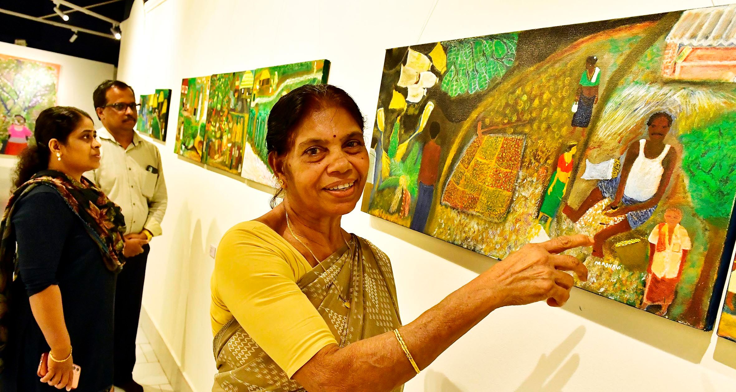 കേരള ലളിത കല അക്കാദമി ആര്‍ട്ട് ഗാലറിയിൽ നടക്കുന്ന " പൂമരങ്ങളും പൊലിവള്ളികളും " ചിത്ര പ്രദർശനത്തിൽ താൻ വരച്ച ചിത്രങ്ങൾക്കരികെ ചിത്രകാരി കെ മാധവി