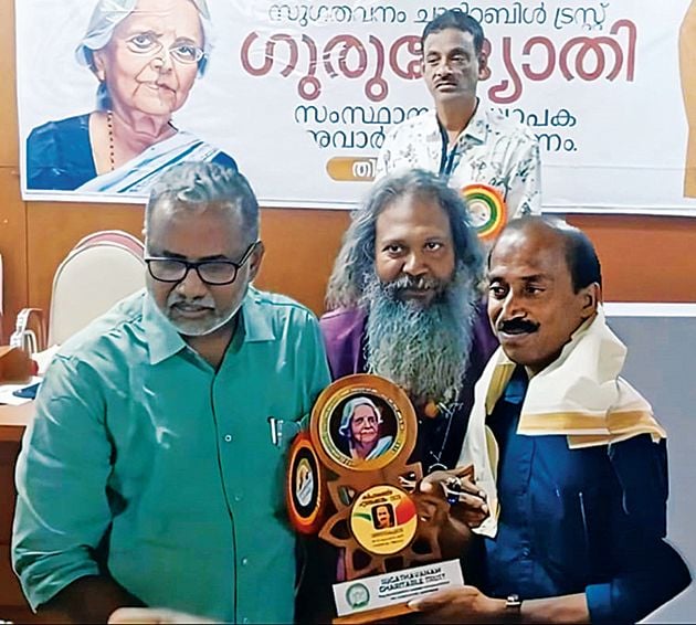 താമരക്കുളം വിവി ഹയർസെക്കൻഡറി സ്കൂളിലെ ഹിന്ദി അധ്യാപകൻ  വിനോദ്കുമാറിന് ഗുരുജ്യോതി കർഷകരത്നം പുരസ്കാരം  മന്ത്രി പി പ്രസാദ് സമ്മാനിക്കുന്നു. ട്രസ്റ്റ് ഡയറക്ടർ ഡോ. ജിതേഷ് ജി സമീപം