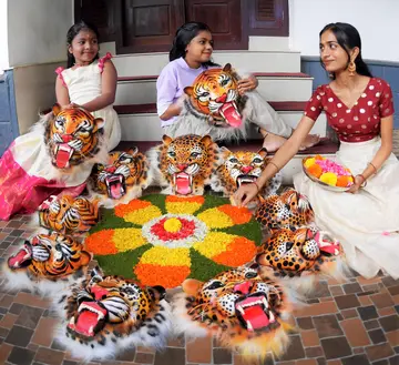 ഉത്രാട നാളിൽ പുതൂർക്കരയിൽ ഇല്ലിക്കൽ വീട്ടിലെ കുട്ടികൾ പുലിമുഖവും പൂക്കളും ഉപയോഗിച്ച്‌ പൂക്കളം ഒരുക്കുന്നു / ഫോട്ടോ: ഡിവിറ്റ്‌ പോൾ