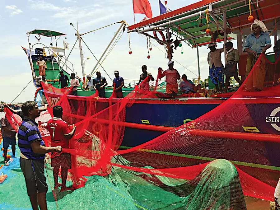 തകർന്ന വലകളുടെ ബാക്കിഭാഗം കരയിലേക്ക്‌ ഇറക്കുന്ന തൊഴിലാളികൾ
