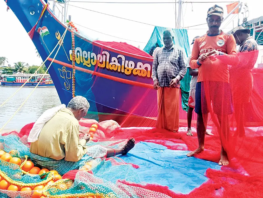 Fishermen repairing damaged nets