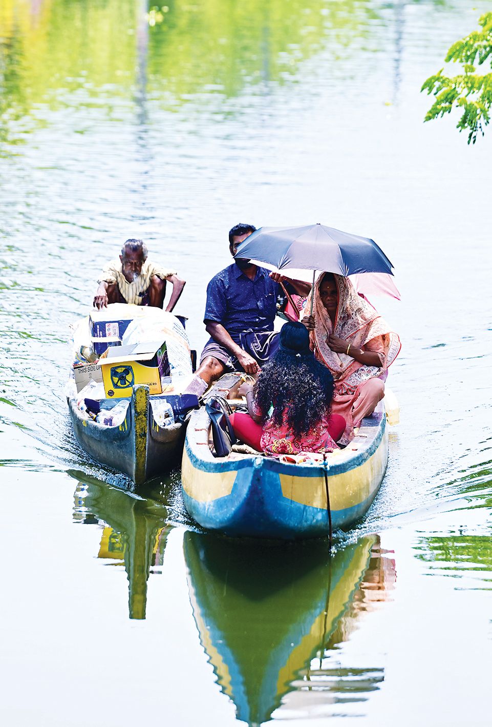 വെയിലിൽനിന്ന് രക്ഷനേടാൻ വള്ളത്തിൽ കുടചൂടി പോകുന്നവർ. ചുങ്കത്തുനിന്നുള്ള ദൃശ്യം