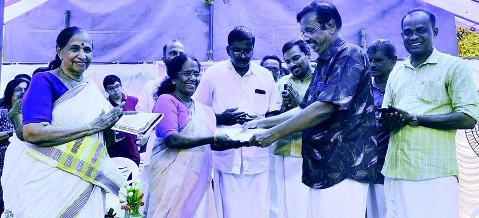 District Panchayat President K G Rajeshwari receives the certificate of Anganwadi from K Aditya Varma