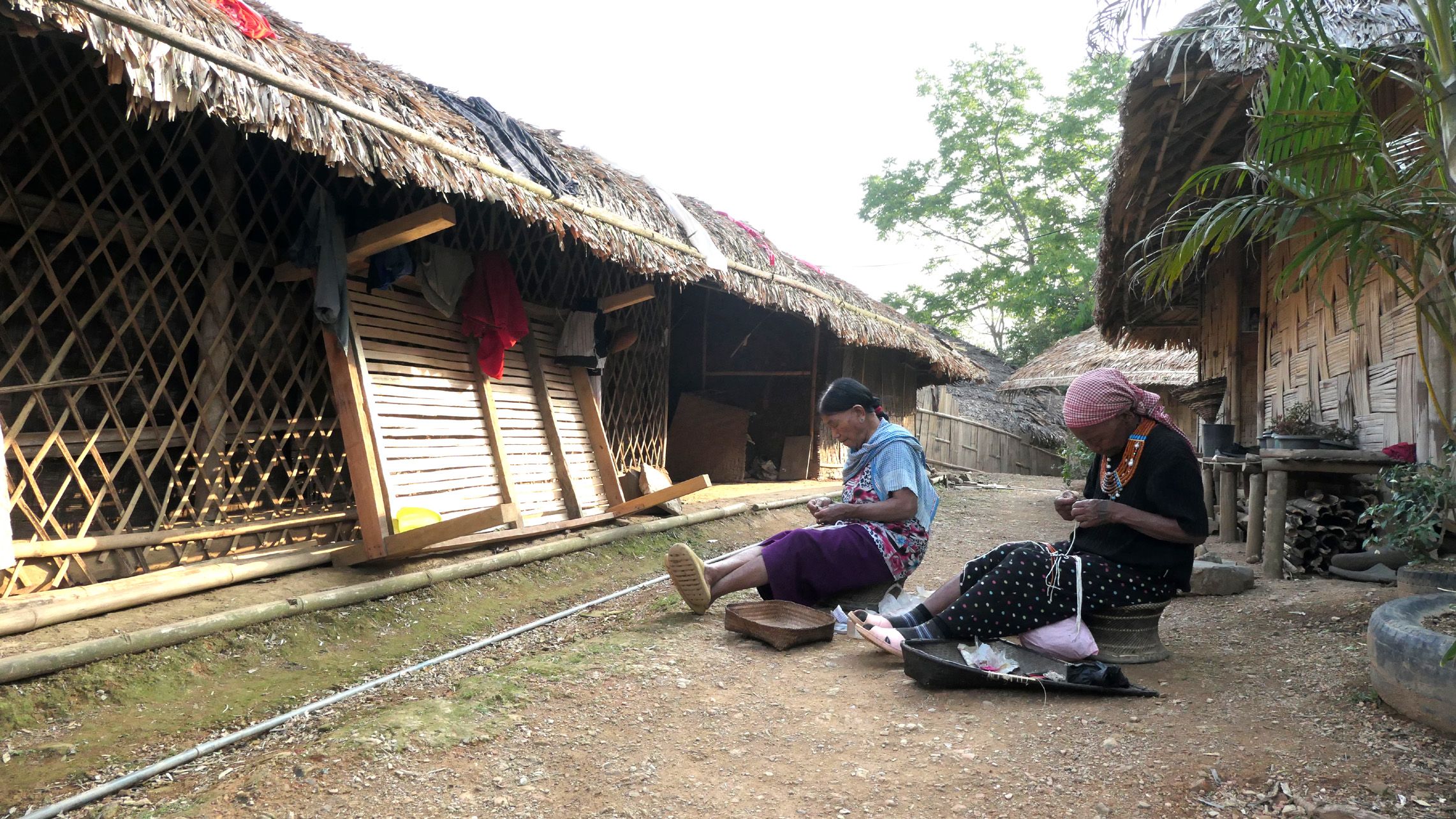 ടോൺയെയുടെ വീടിനു പുറത്തിരുന്ന്‌ മുത്തുമാല കോർക്കുന്ന അമ്മമാർ