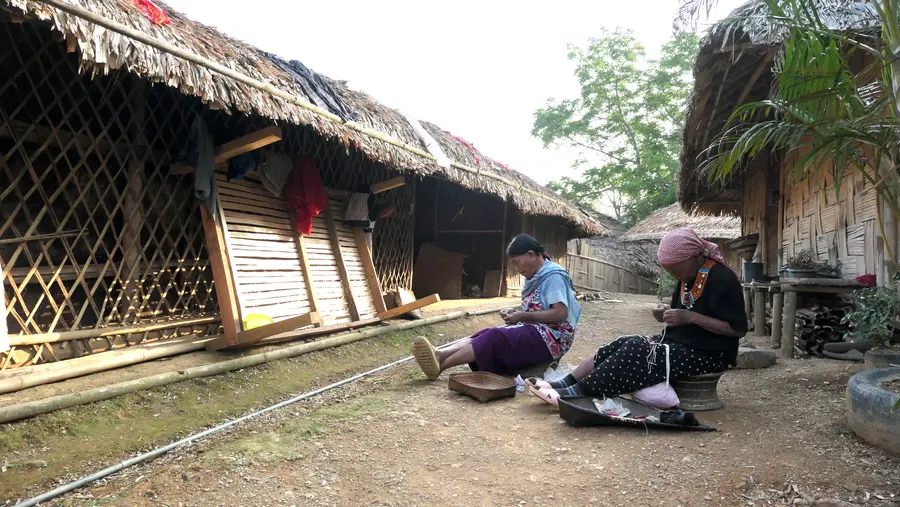 ടോൺയെയുടെ വീടിനു പുറത്തിരുന്ന്‌ മുത്തുമാല കോർക്കുന്ന അമ്മമാർ