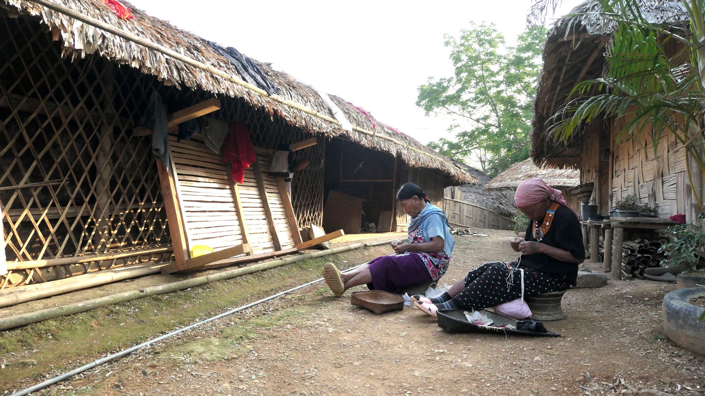 ടോൺയെയുടെ വീടിനു പുറത്തിരുന്ന്‌ മുത്തുമാല കോർക്കുന്ന അമ്മമാർ