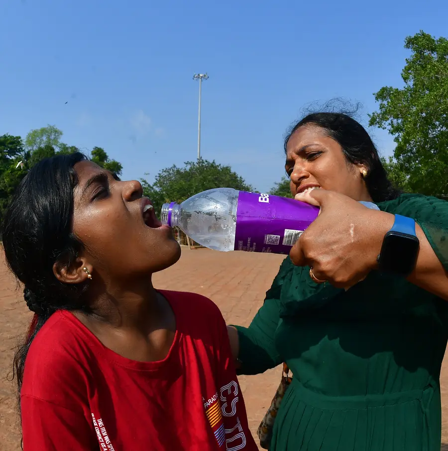 കനത്ത വെയിലിൽ തളർന്ന മകൾക്ക്‌ വെള്ളം കൊടുക്കുന്ന അമ്മ. തേക്കിൻകാട്‌ മൈതാനിയിൽ നിന്നുളള ദൃശ്യം                                                                                                                                                                                                             / ഫോട്ടോ: ഡിവിറ്റ്‌ പോൾ 