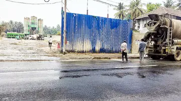 പരാതി ഉയർന്നതിനെ തുടർന്ന് പൊടിപടലമുണ്ടാവാതിരിക്കാൻ റോഡ്  നനയ്‌ക്കുന്ന  കമ്പനി ജീവനക്കാർ