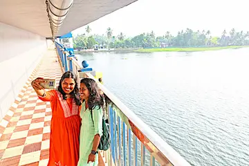 പടഹാരം പാലത്തിലെ നടപ്പാതയിൽനിന്ന് കുട്ടനാടിന്റെ സൗന്ദര്യം ആസ്വദിച്ച്  പൂക്കൈതയാർ പശ്ചാത്തലമാക്കി   സെൽഫിയെടുക്കുന്നവർ 