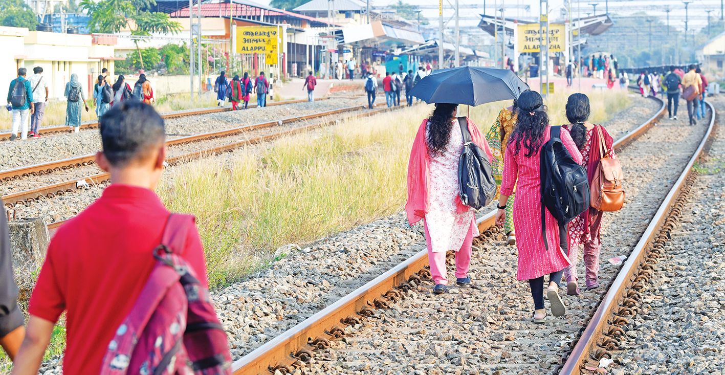 Passengers walk to the platform along the tracks, avoiding the railway station road due to ongoing construction work.