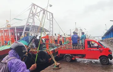 പൊന്നാനി ഹാർബറിൽ ബോട്ടുകളിൽ നിന്ന് വല മാറ്റുന്നവർ