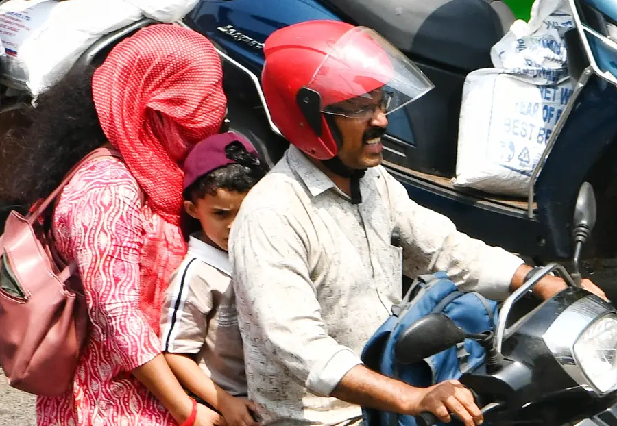 ഹെൽമെറ്റ് ഇല്ലെങ്കിൽ പൊള്ളും .. ചുട്ടുപൊള്ളുന്ന വെയിലിനെ മറക്കാൻ ഷാൾ ഉപയോഗിച്ച് തല മറച്ചു--പോകുന്ന ബൈക്ക് യാത്രിക. പാളയത്ത് നിന്നുള്ള ദൃശ്യം