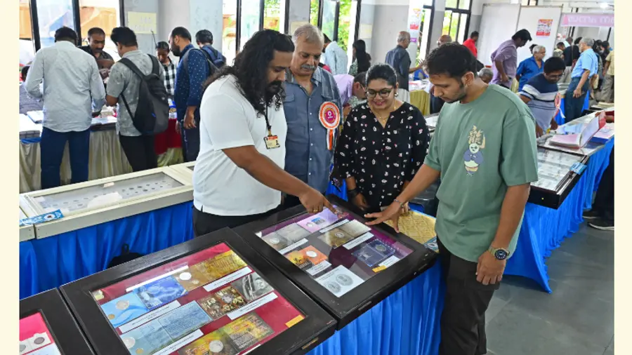 അഭിജിത്തും അച്ഛൻ സന്തോഷും പ്രദർശനം കാണാനെത്തിയവർക്ക്  നാണയങ്ങളെക്കുറിച്ച് വിശദീകരിക്കുന്നു 