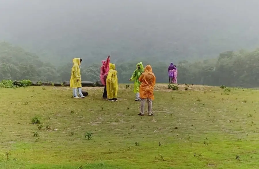 കവയിൽ മഴ ആസ്വദിക്കുന്ന സഞ്ചാരികൾ