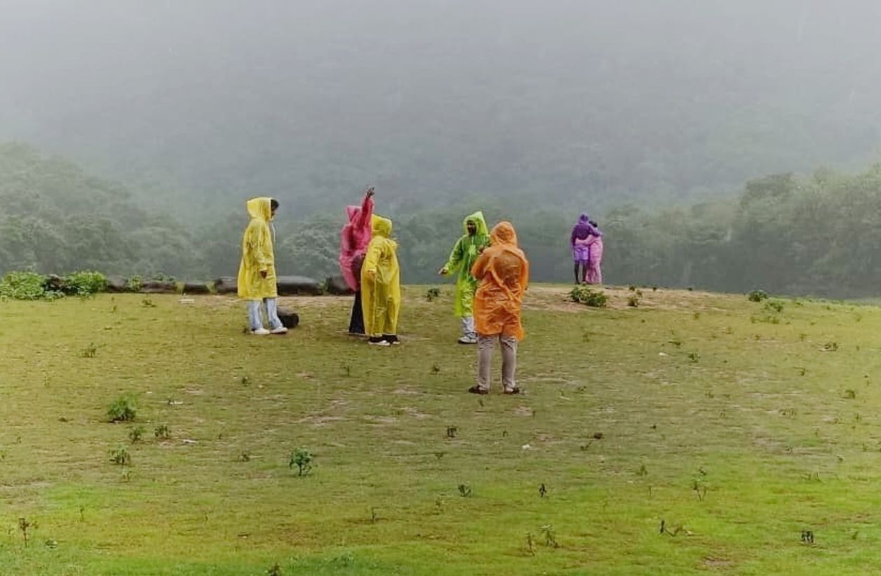 കവയിൽ മഴ ആസ്വദിക്കുന്ന സഞ്ചാരികൾ