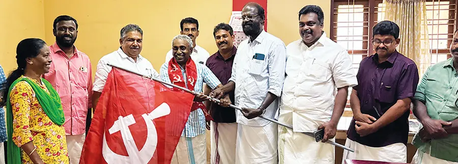 മന്ത്രി സജി ചെറിയാൻ സജി ചരവൂരിനെ പാർടി പതാക നൽകി സ്വീകരിക്കുന്നു