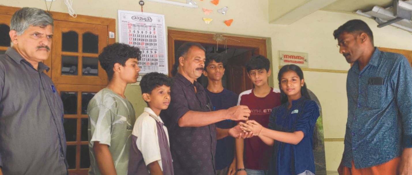 കളഞ്ഞുകിട്ടിയ സ്വർണാഭരണം കുട്ടികളുടെ സാന്നിധ്യത്തിൽ  പഞ്ചായത്ത് അംഗം അബ്ദുൽ മജീദ് ഉടമയായ ഗൗതമിക്ക് കൈമാറുന്നു